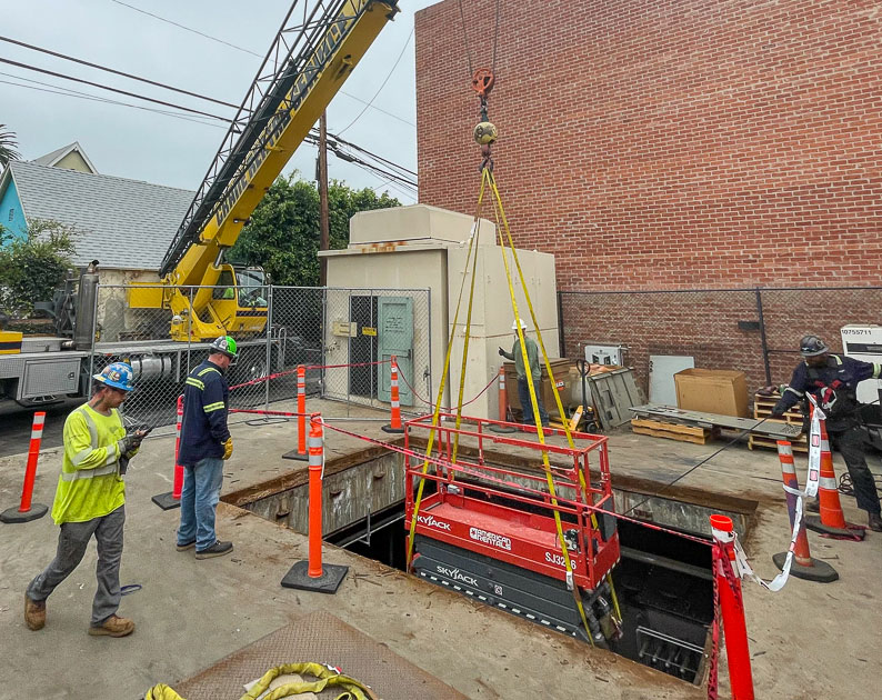 The Walker Brothers machinery moving team lifting power equipment out of an underground substation.